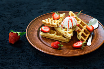 Breakfast. Viennese waffles with strawberries, cherries, summer berries on a plate on a black background