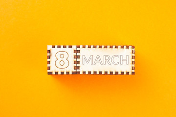 Fototapeta premium wooden cubes with the inscription March 8 on orange background. 8 march and women day concept