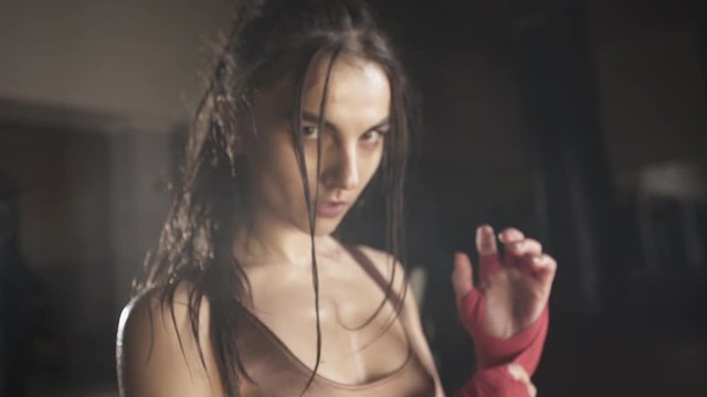 Hot sweaty young woman bandaging her hands