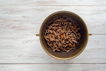 Fried beef in a cauldron. Fried beef stroganoff. 