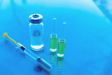Syringes, medicine bottles on a blue background