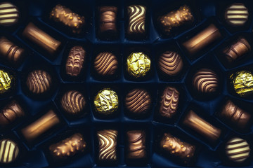 Chocolate candies arranged in the blue box, top close view