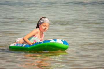 Dziewczynka pływająca na pontonie w morzu