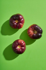 Ripe raf tomatoes on green background