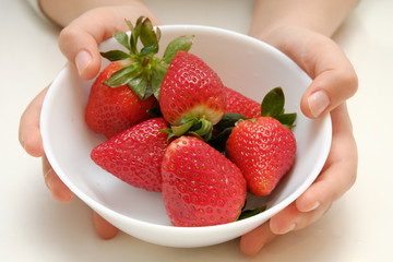 Close up strawberry in white plate, hand holding plate with berries