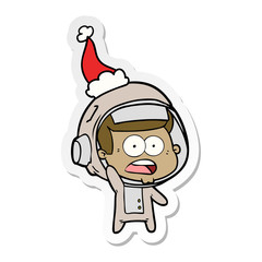 sticker cartoon of a surprised astronaut wearing santa hat