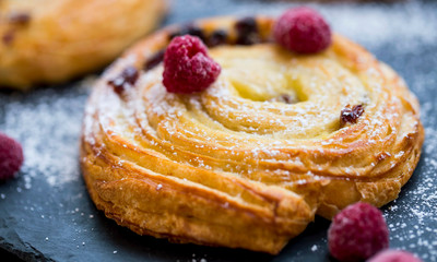 French pastry bun rolls with raisins, vanilla and raspberries. Pain aux raisins et vanille, fresh...