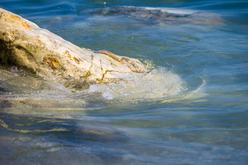 pebble stones on the sea beach, the rolling waves of the sea with foam