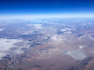 An aerial view of Chinese mountains from the airplane flying high above the ground. A look from the plane&acute;s window. 