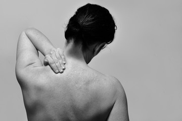 middle-aged woman with pain in the upper part of the spine