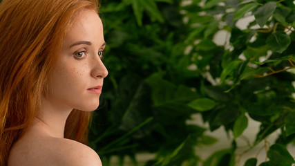 Fototapeta premium Young redhead woman looking away in nature,