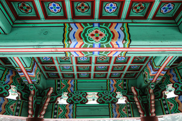 A detail Picture of a traditional wooden roof of a Korean palace. You can see the ornaments and decorations. 