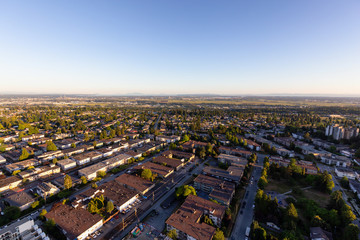 Aerial view of a residential suburban neighborhood during a vibrant summer sunset. Taken in Burnaby, Vancouver, BC, Canada.