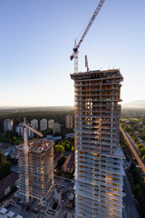 Aerial view of a residential building construction site during a vibrant summer sunset. Taken in...
