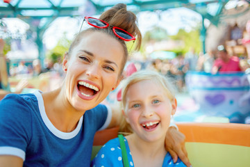 mother and child tourists in theme park enjoying attraction