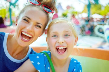Peel and stick wallpaper Amusement parc smiling mother and child tourists in theme park having ride