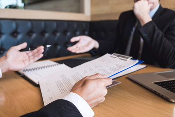 Employer or recruiter holding reading a resume during about his profile of candidate, employer in suit is conducting a job interview, manager resource employment and recruitment concept