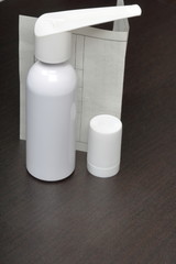 Inhaler for the treatment of respiratory organs. Spray can and cap white. Next recipe to buy. On a dark surface.