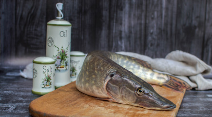 Fish pike with spices on a wooden board. Pike on a cutting wooden board prepared. 