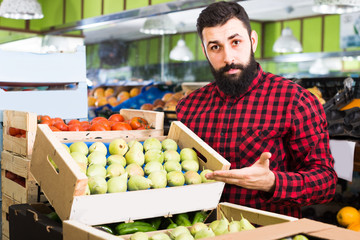 man seller showing pears