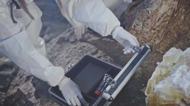 Female scientist or geologist sampling a crystal