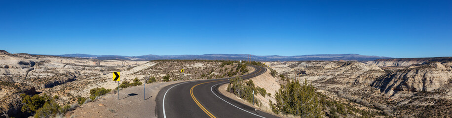 Fototapeta premium Scenic road in the desert during a vibrant sunny day. Taken on Route 12, Utah, United States of America.