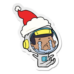 sticker cartoon of a crying astronaut wearing santa hat