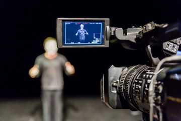 Actor in front of the camera. LCD display on the camcorder. Filming in the interior.