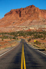Scenic road in the desert during a vibrant sunny sunrise. Taken on Route 24 near Torrey, Utah, United States of America.