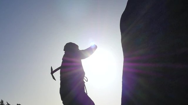 man in hoodie hits the stone rock with pickaxe slow motion silhouette
