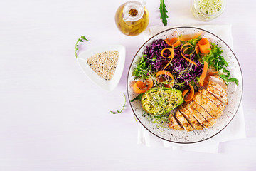 Buddha bowl dish with chicken fillet, avocado, red cabbage, carrot, fresh lettuce salad and sesame....