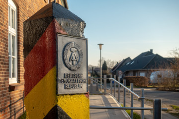 a pole with the coat of arms of the GDR stands in a village