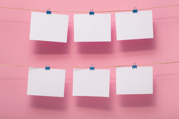place for photo cards of moments of life, empty blanks attached to a linen rope with stationery clips on a colored background, a concept template for text, images, idea for home decor