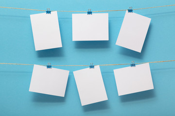 place for photo cards of moments of life, empty blanks attached to a linen rope with stationery clips on a colored background, a concept template for text, images, idea for home decor