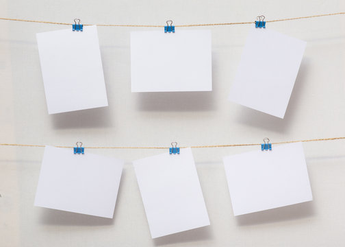 papers for writing reminders in the office, useful decor, empty templates for text and photos on colored stationery clips on the background of white cotton fabric