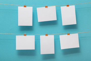 place for photo cards of moments of life, empty blanks attached to a linen rope with stationery clips on a colored background, a concept template for text, images, idea for home decor