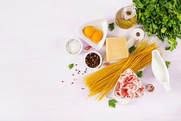 Ingredients for cooking Carbonara pasta, spaghetti with pancetta, egg, peppers, salt and hard parmesan cheese. Italian cuisine. Pasta alla carbonara. Top view, flat lay, copy space