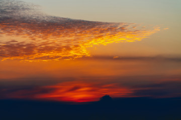 Sunny shine on clouds. Wonderful vivid dawn. Beautiful calm red sunset. Scenic surreal sunrise. Amazing scenery of orange cloudy sky. Picturesque sundown. Atmospheric cloudscape. Natural background.