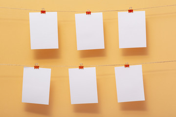 place for photo cards of moments of life, empty blanks attached to a linen rope with stationery clips on a colored background, a concept template for text, images, idea for home decor