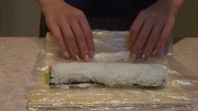 Close up of a woman preparing homemade sushi