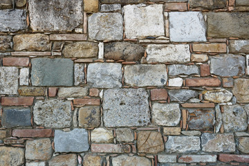 Squared stone masonry background with white, red, grey and black stones. Landscape format.