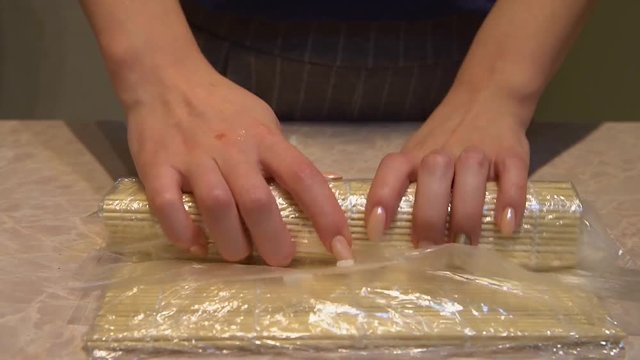 Close up of a woman preparing homemade sushi
