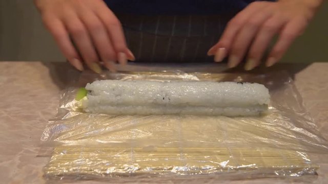 Close up of a woman preparing homemade sushi