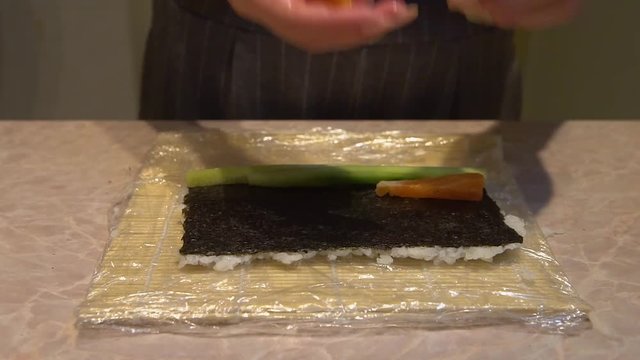 Close up of a woman preparing homemade sushi