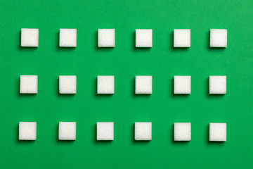 Fototapeta na wymiar sugar cubes on green background