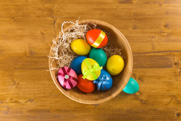 Obraz na płótnie Canvas easter eggs in wooden bowl on wooden background