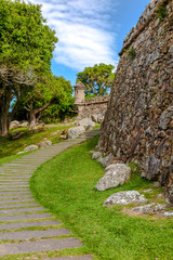 Stone path and lawn, next to the wall of theFortress Sao Jose da Ponta Grossa, Florianopolis, Santa Catarina, Brazil