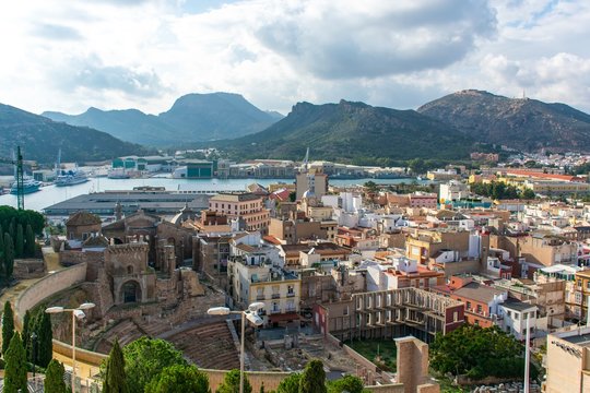 An elevated view of Cartagena harbour showing the ancient roman amphitheatre in the foreground and the mountains on the far-side of the water