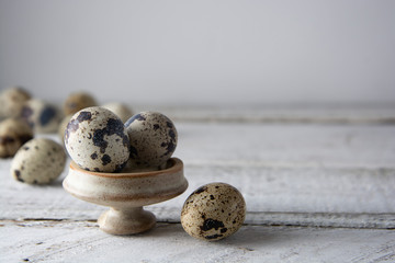 Quail eggs over white wooden background. Isolated quail raw eggs. rustic style.