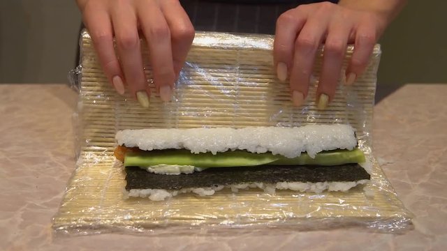 Close up of a woman preparing homemade sushi